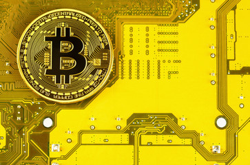 Gold bitcoin Bitcoin on motherboard Gold bitcoin cryptocurrency on computer circuit board.