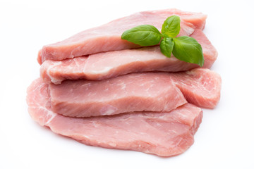 Fresh pork fillet with basil on a white background.