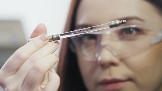 Assistant Holds Small Tube with Crude Oil Drops