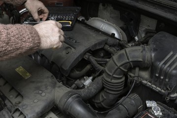 the car mechanic fixes the car engine by tools