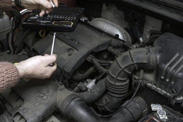 Fototapeta na wymiar the car mechanic fixes the car engine by tools
