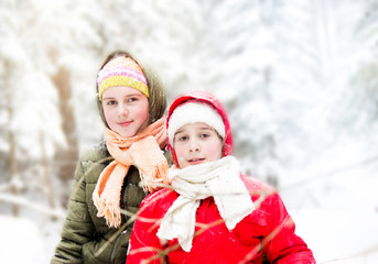 Fototapeta premium Two happy little girls in snowy forest