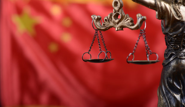 Scales of Justice, Justitia, Lady Justice in front of the flag of China in the background.