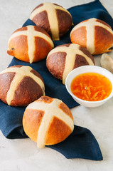 Homemade chocolate and classic hot cross buns with raisins on a white stone background. Copy space.