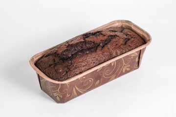 Homemade cacao bread in the baking paper mold on white background