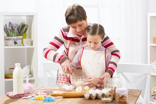 Mother and daughter cook at home. Making cookies, kitchen interior, healthy food concept