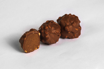 Cut chocolate truffles on white background