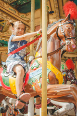 6 years girl on the toy horse in the amusement park