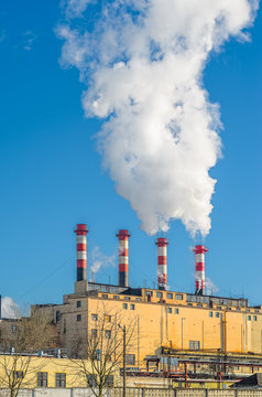 Thermal power plant during winter operation. High chimneys emit a large amount of smoke