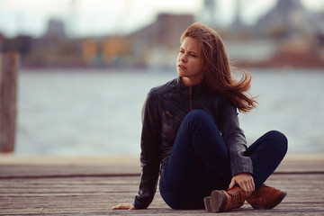 girl in a leather jacket sits outside the rustic style
