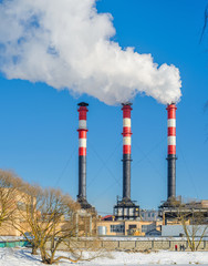 Thermal power plant during winter operation. High chimneys emit a large amount of smoke