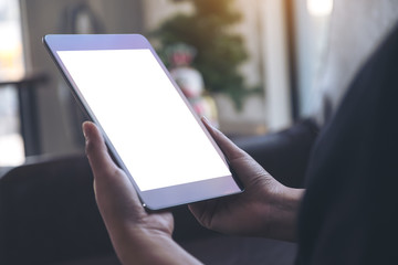 Mockup image of hands holding black tablet with blank white desktop screen