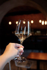 A glass of white wine in a woman's hand