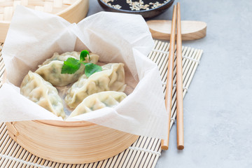 Steamed Korean dumplings Mandu with chicken meat and vegetables in bamboo steamer, horizontal, copy space