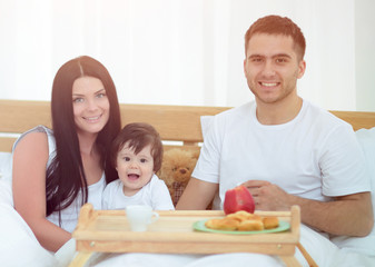 Family having breakfast in bed at home