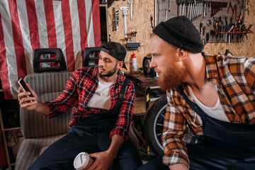 handsome mechanics taking selfie at garage