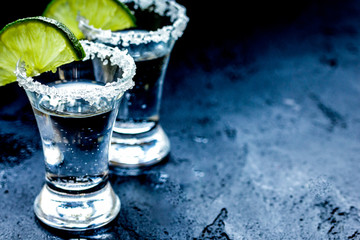 Alcohol shots with lime and salt on black background