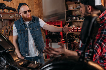 Fototapeta na wymiar bike repair worker having argue with customer at garage