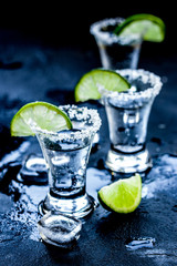 Alcohol party with tequila, ice and salt on black background