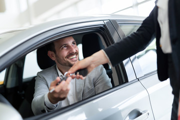 Portrait of happy customer buying new car