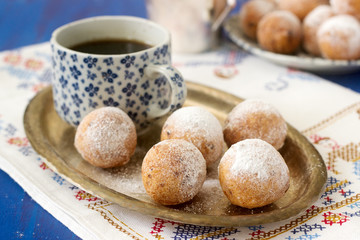 Vanilla krapfen doghnut with coffee. Rustic style.