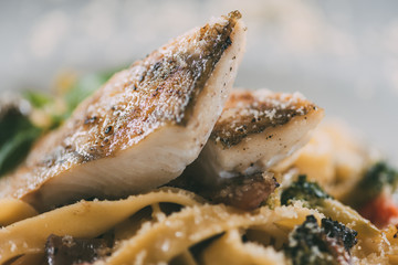 delicious pasta with pike perch fillet, vegetables and parmesan cheese