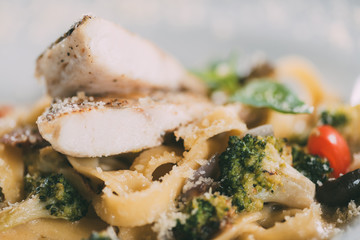 close-up view of gourmet pasta with pike perch fillet, vegetables and parmesan cheese