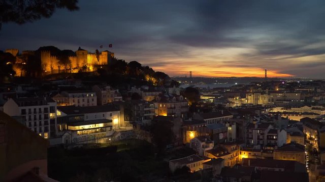 Sunset view of Lisbon old town, Portugal. Roofs of the city, Castelo de Sao Jorge and 25th of April Bridge. Zoom out shot.