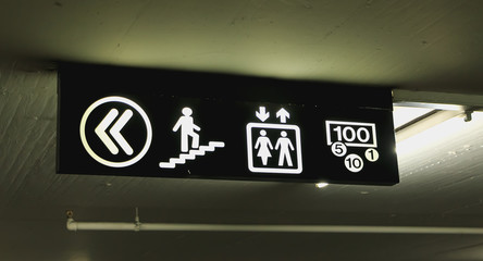 illuminated signs that indicates the direction of the stairs elevator and cash machine