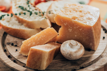 close-up view of delicious baguette and parmesan cheese with mushroom on wooden cutting board