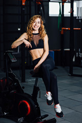 Fototapeta na wymiar athletic girl stand near a bicycle simulator
