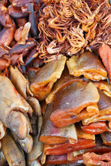 Pieces of grilled smoked salmon fish, squid and octopus with spices and pepper.