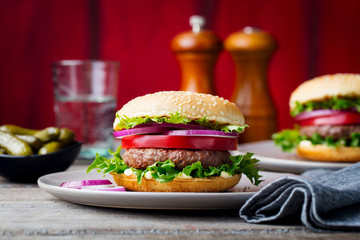 Burger on a plate. Wooden background. Copy space.