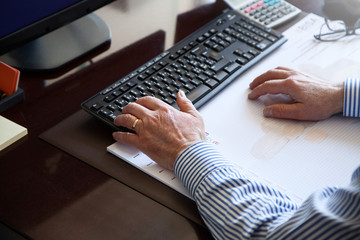 Personne qui tape au clavier sur son ordinateur de bureau