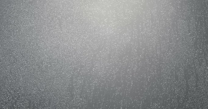rain drops falling down on glass grey background, water droplets on window glass