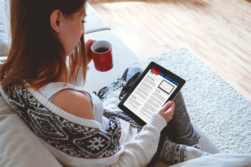 Woman reading news on tablet with cup of coffee. Online education concept. e-Learning