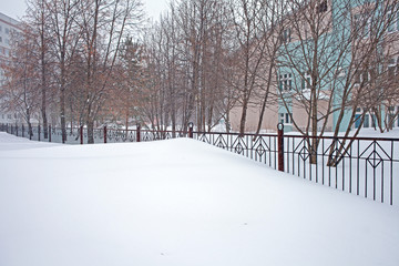 Snow storm in the city, big heaps of snow, cityscape in winter