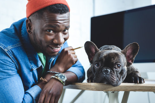 Handsome African American Man With Frenchie Dog By Computer Screen