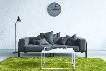 Modern room with digital gadgets on table by sofa