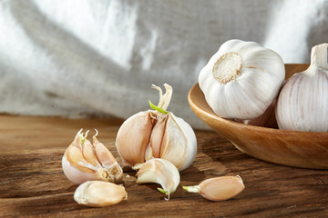 Garlic close up on wooden plate on rustic background, shallow depth of field, selective focus, macro.