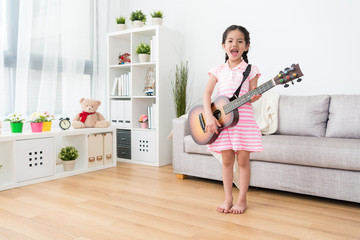 Girl playing guitar happily.