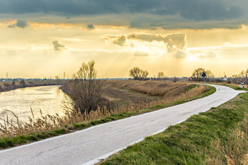 sunset on road along river