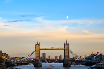 Obraz na płótnie Canvas London, England Blick über Themse auf die Tower Bridge bei sonnigem Wetter zur goldenen Stunde mit Mond