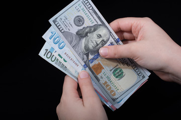 Hand holding American dollar  isolated on black background
