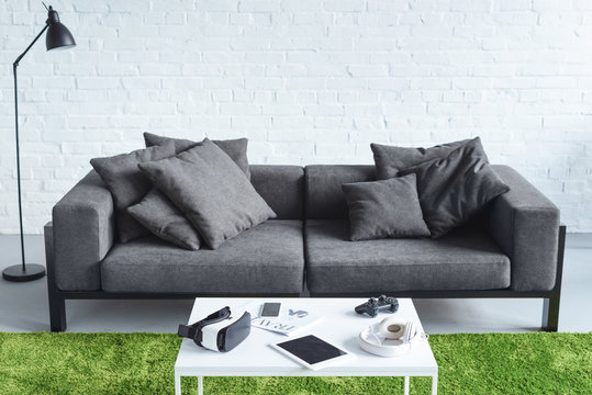 Digital gadgets in cozy interior with modern grey sofa - Powered by Adobe