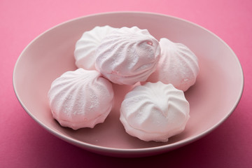 Tasty sweet zephyr on pastel pink background.