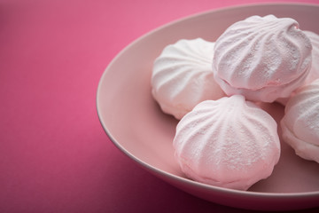 Tasty sweet zephyr on pastel pink background.