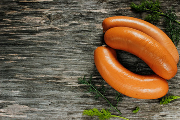 sausages with dill greens on a wooden surface.