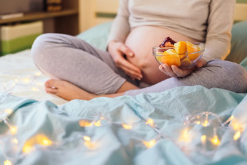 Portrait of pregnant woman's belly and healthy food