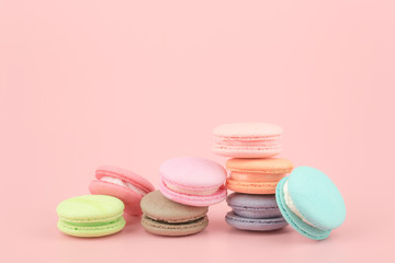 Sweet French macaroons cake (or macarons) with vintage pastel colored tone on pink background.